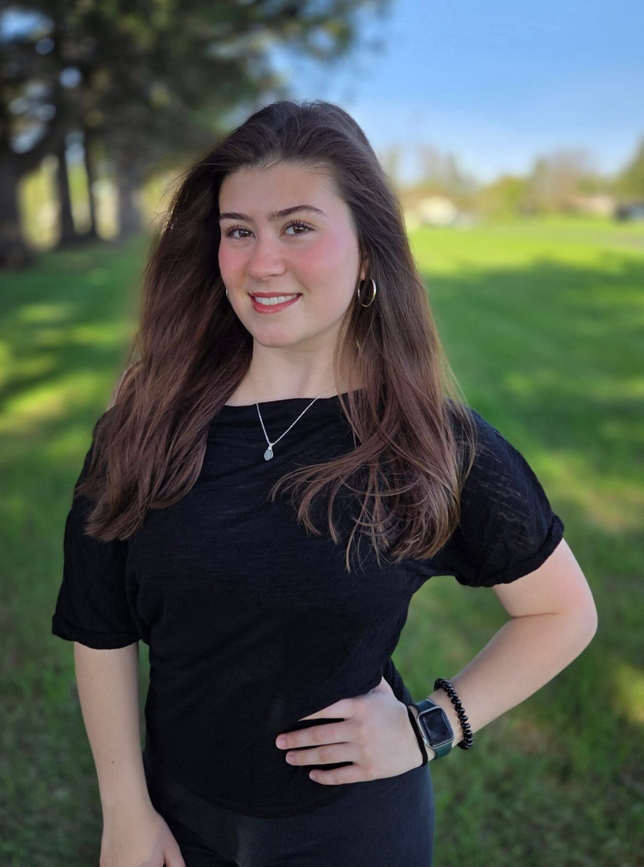 Smiling woman standing in a green field.